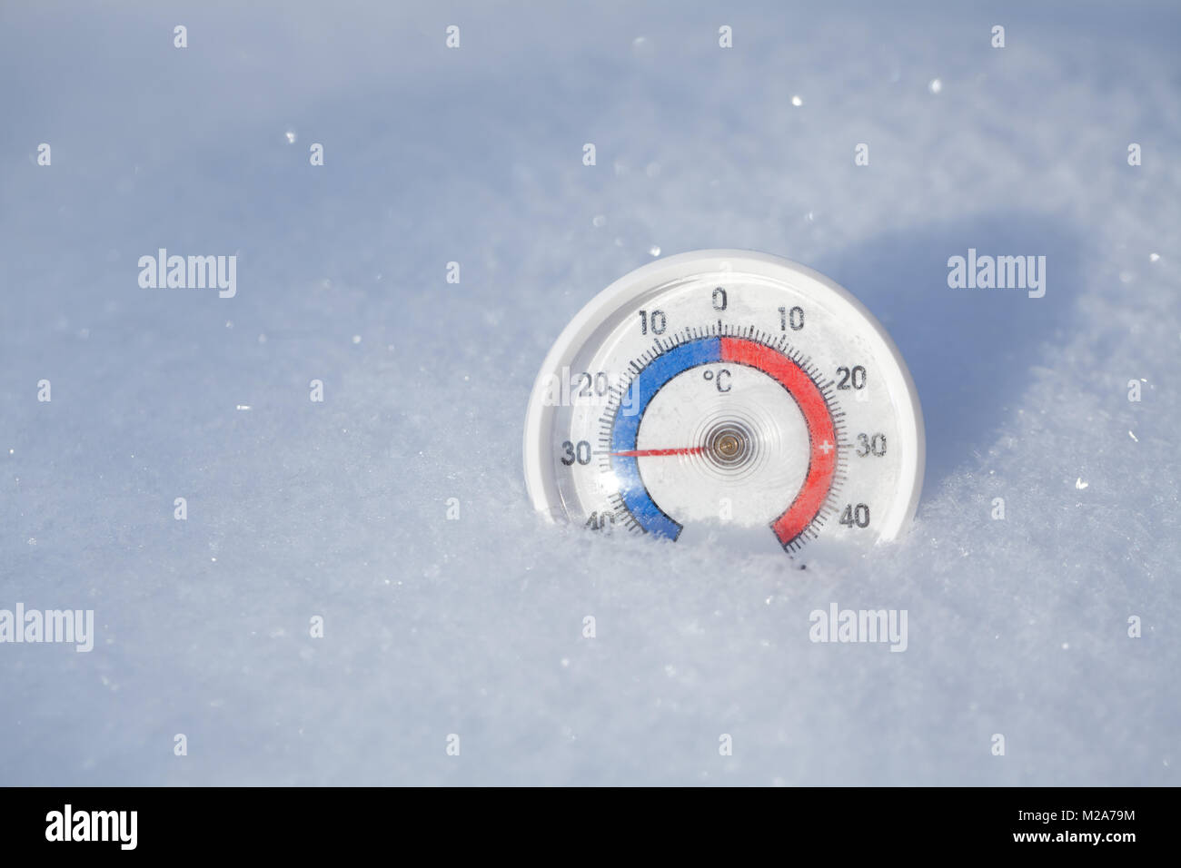 Thermometer with celsius scale placed in a fresh snow showing sub-zero temperature minus 30 degree - extreme cold winter weather concept Stock Photo