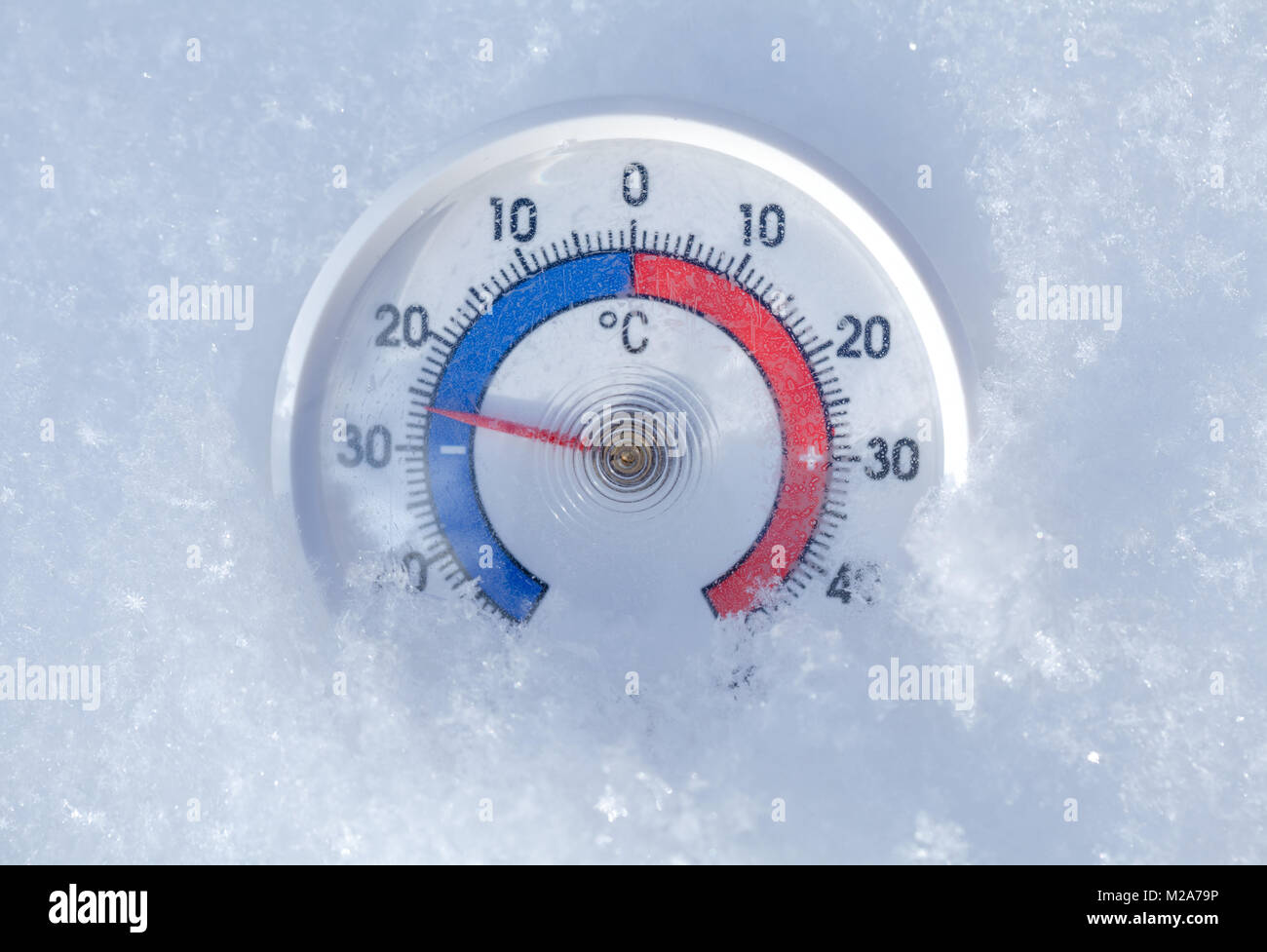 Thermometer with celsius scale placed in a fresh snow showing sub-zero temperature minus 26 degree - frosty winter weather concept Stock Photo