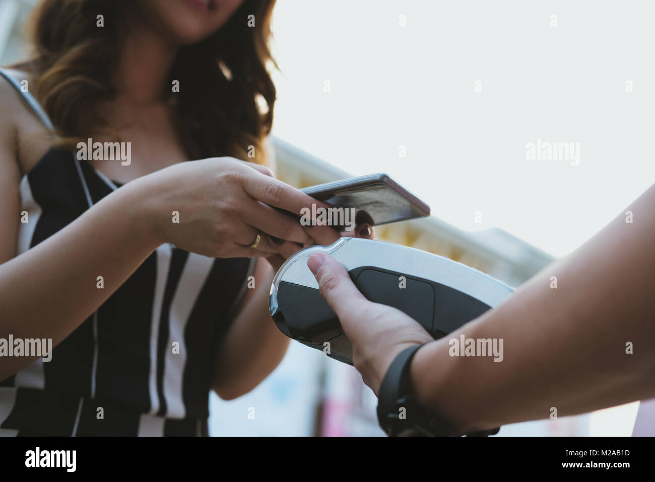 woman use smartphone to make mobile payment with electronic reader ...