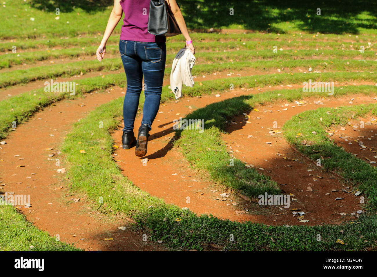 A detail picture of a maze or labyrinth made from grass and soil. Someone is just walking through and tries to find the way out. Stock Photo