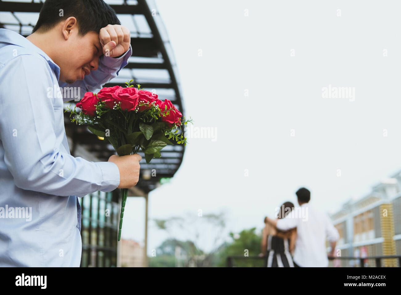asian heartbroken man holding bouquet of red roses feeling sad ...