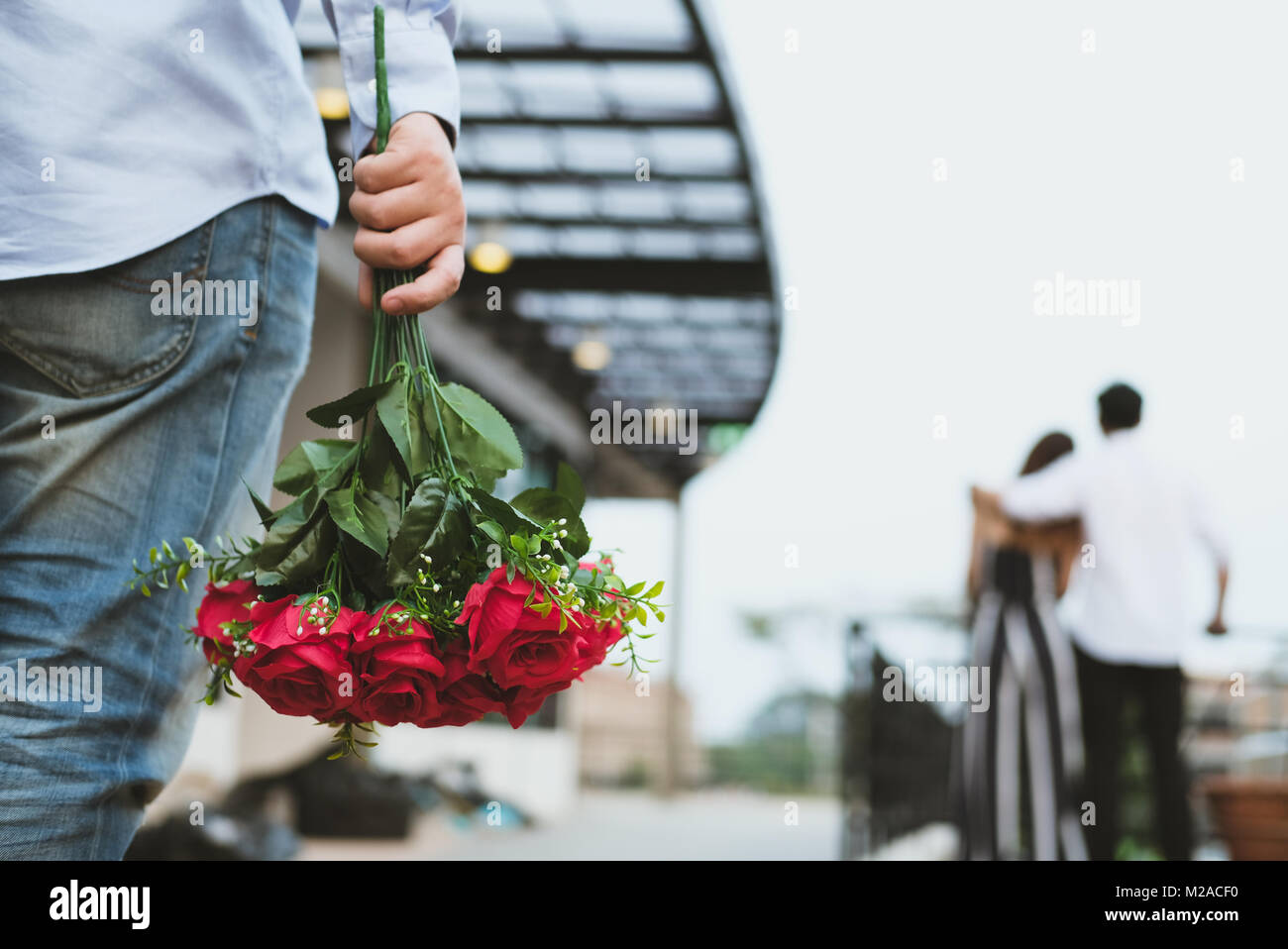 asian heartbroken man holding bouquet of red roses feeling sad ...