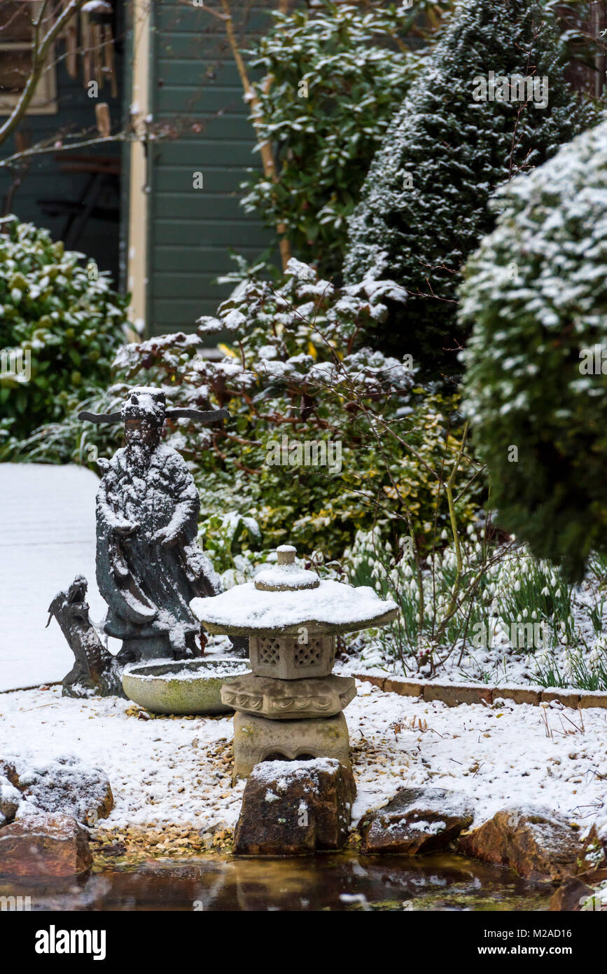Light snow covering on a landscaped English surburban garden. Stock Photo