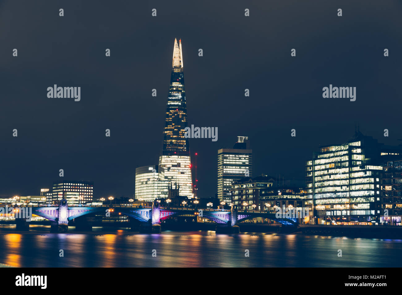 London skyline at night with shard building lights and reflections on River Thames Stock Photo