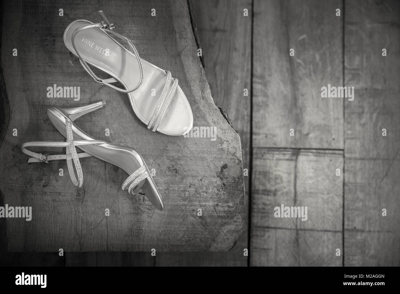 Pair of high heel ladies silver sandals on wooden background, overhead view Stock Photo