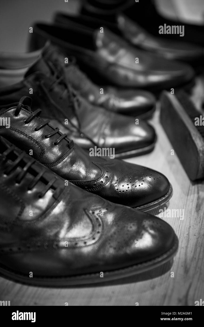 Row of men's shoes with shoe brush, close-up, black and white Stock Photo