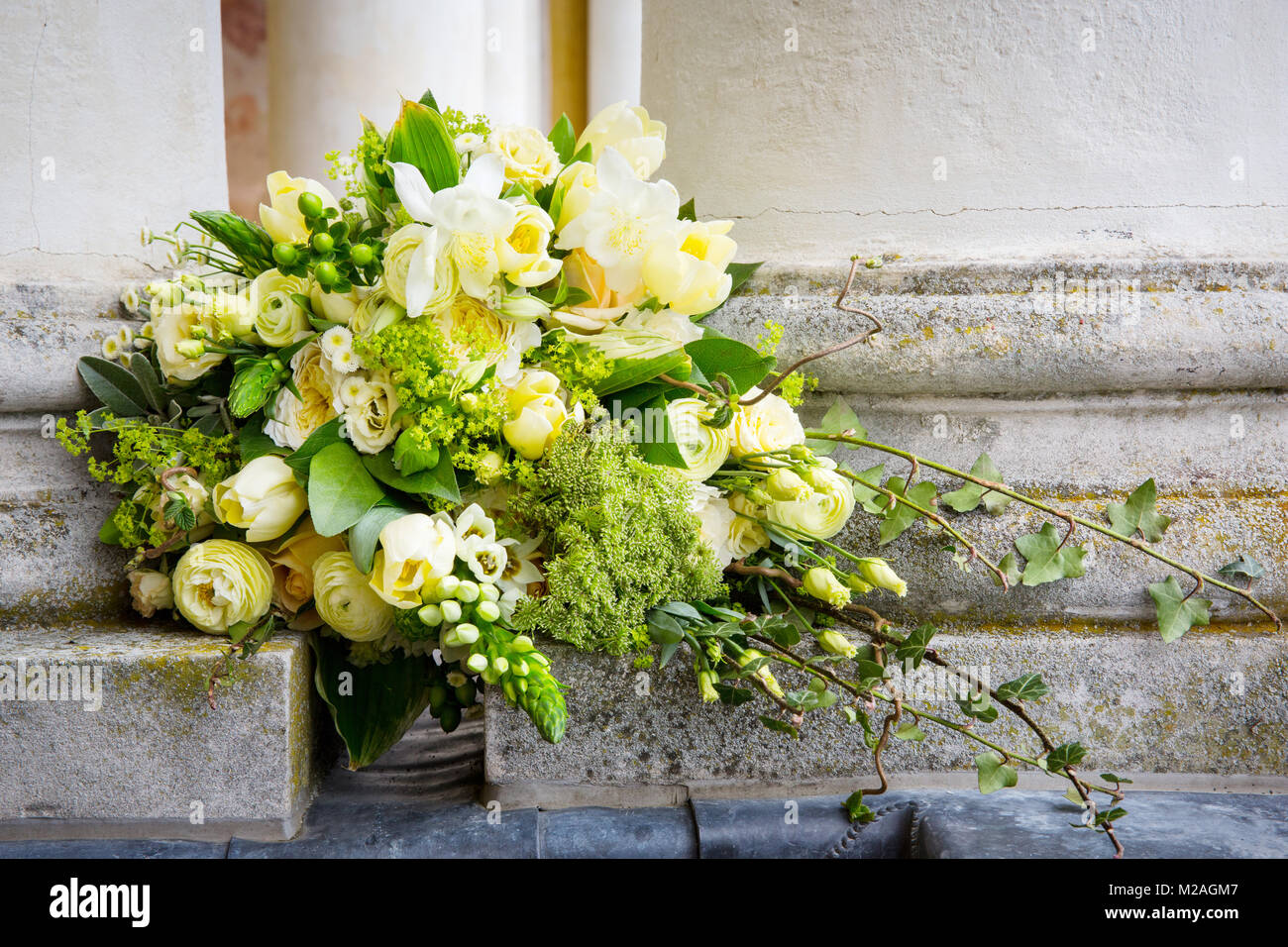 Cream and green floral arrangement set into wall Stock Photo