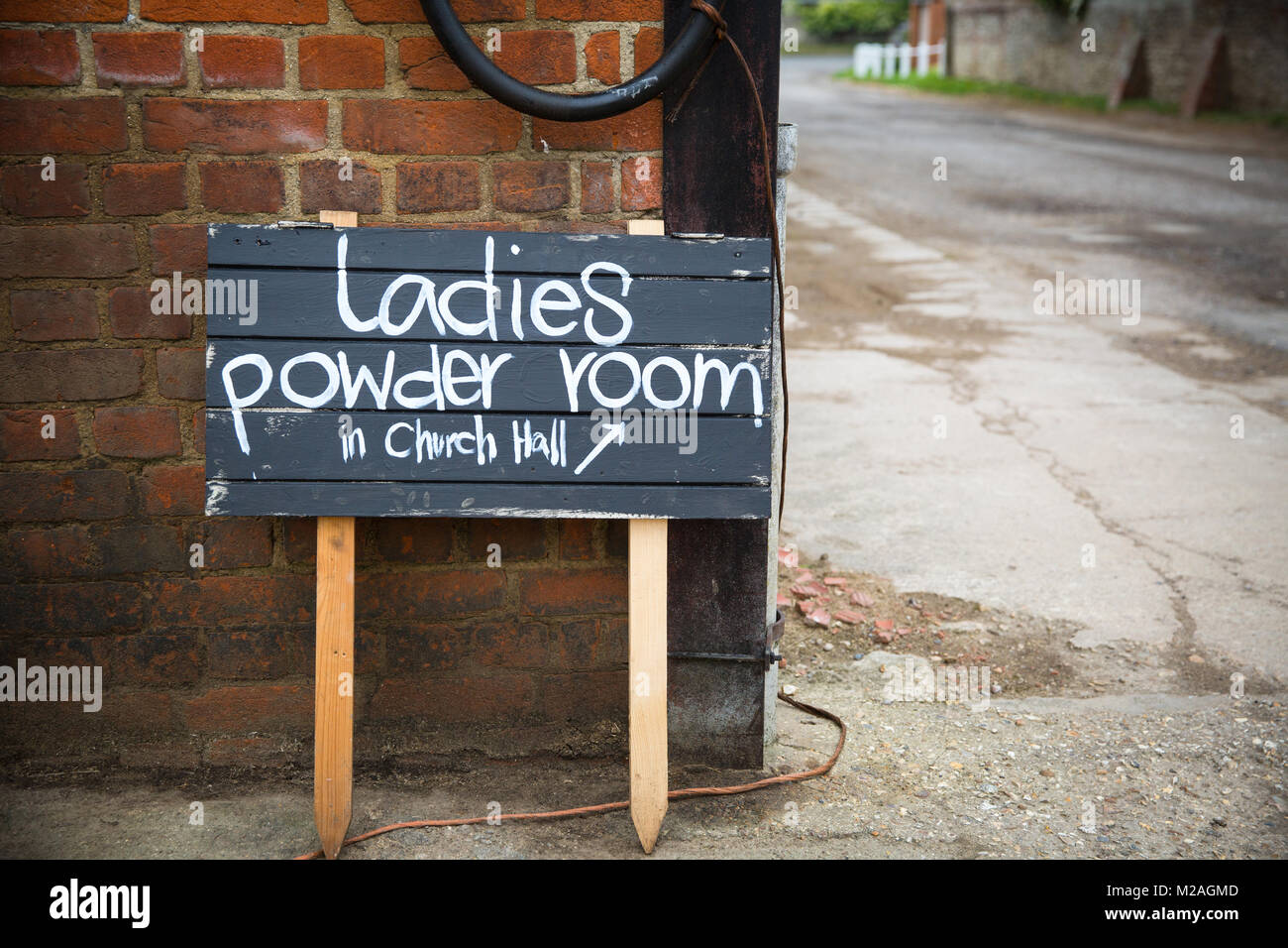 Wooden sign showing direction to ladies powder room Stock Photo