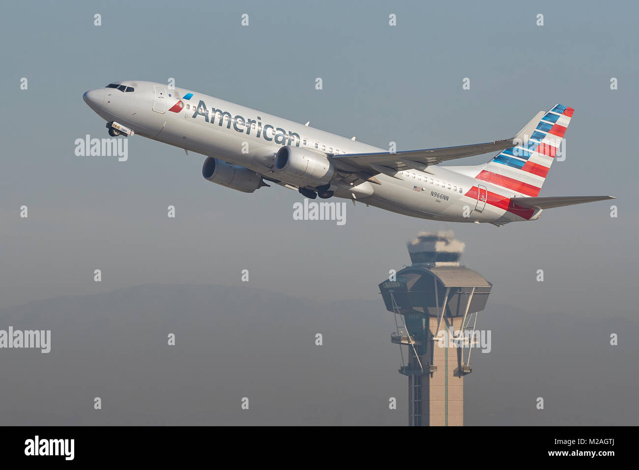 American Airlines Boeing 737-800 Taking Off From Runway 25 Left At Los Angeles International Airport, The Control Tower In the Background. Stock Photo