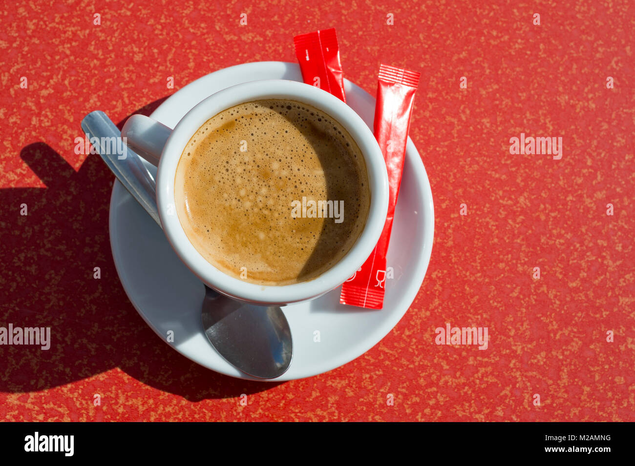 cup of fresh coffee on a red cafe table viewed from above. Stock Photo