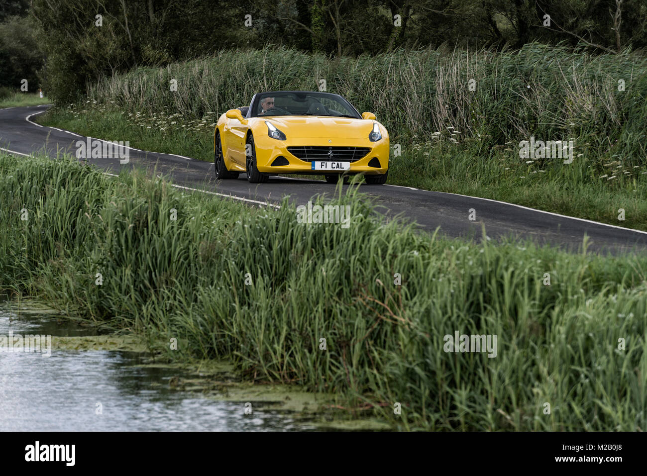 A yellow Ferrari F1 California pictured on The Gwent Levels between Newport and Cardiff, South Wales. Stock Photo