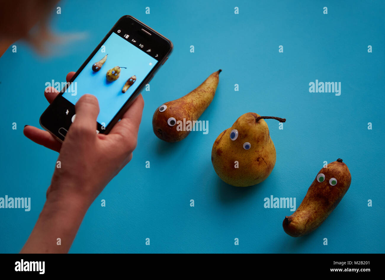 Three funny pears with googly eyes Stock Photo