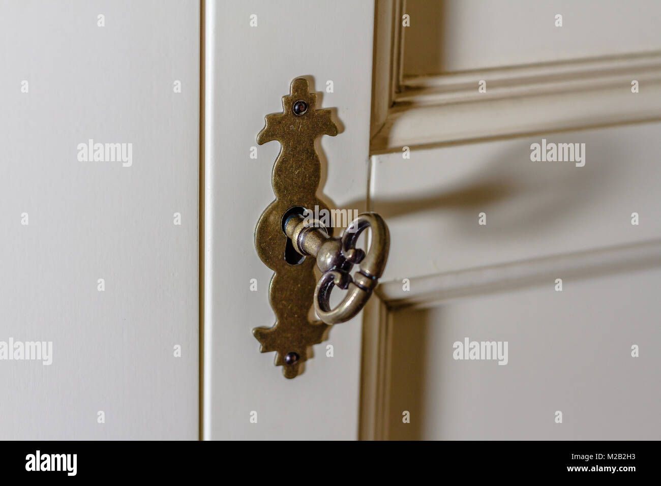 Decorative key in a lock on a cupboard Stock Photo