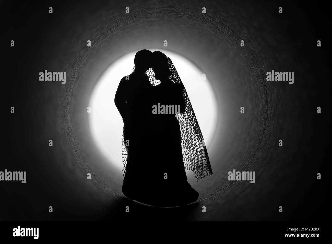 Marriage crisis. Bride and groom figures in a dark tunnel Stock Photo