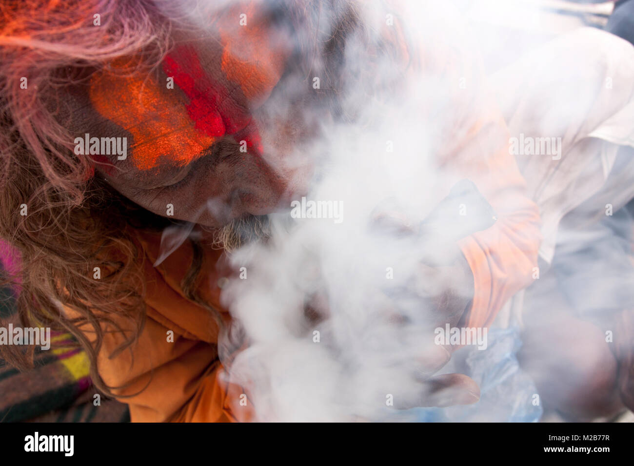 A sadhu smokes marijuana in Pashupati temple area in Kathmandu, Nepal. Stock Photo