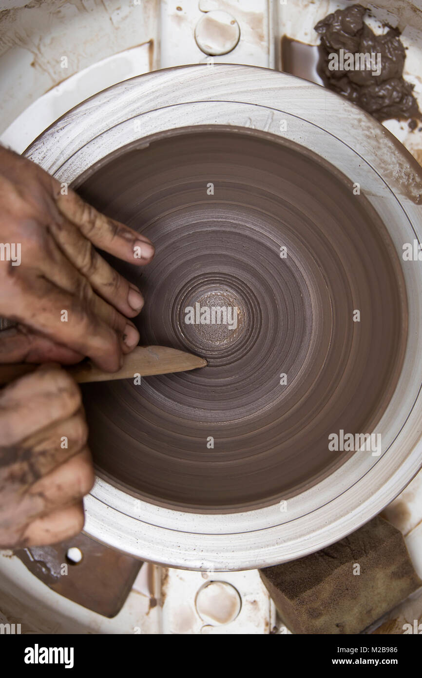 Close up detail view at an artist makes clay pottery on a spin wheel