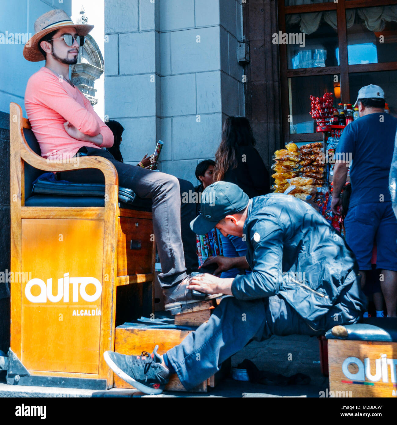 Quito, Ecuador, December 17, 2017: Shoe shine worker shines a client's shoes in the historic centre of Quito, Ecuador Stock Photo