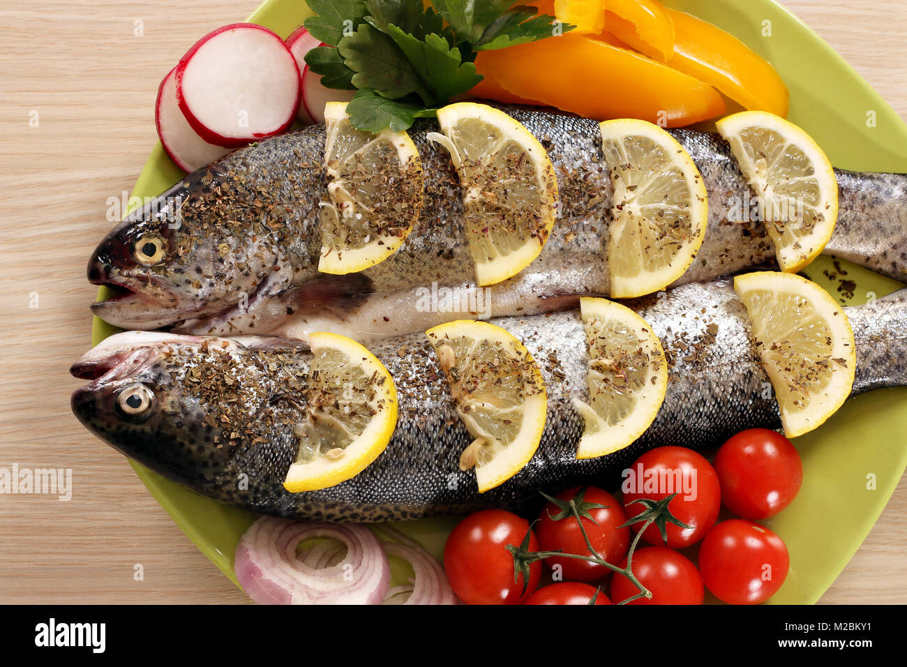 two trout fish with vegetables on plate Stock Photo