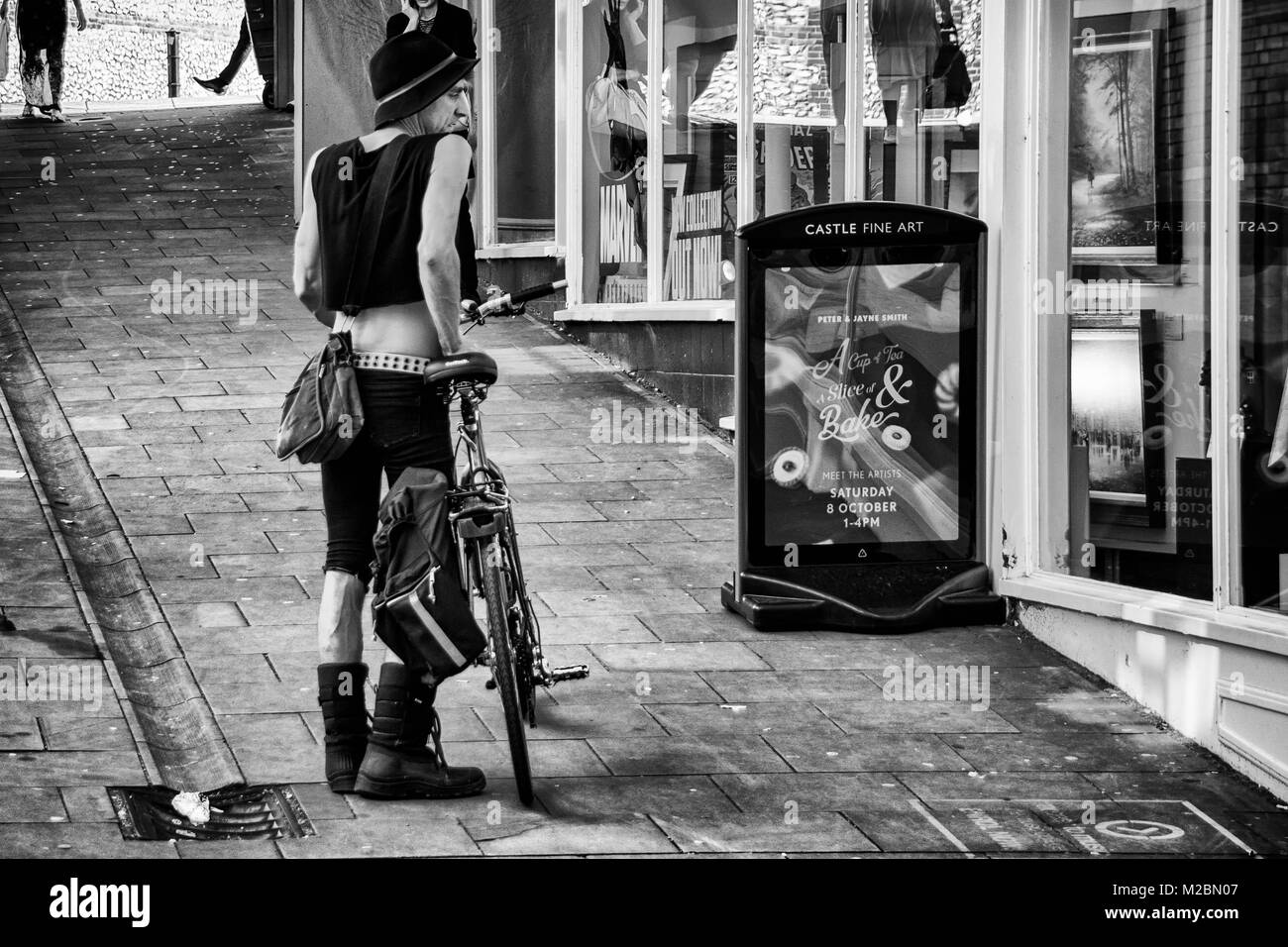 Male Cyclist admiring a shopfront in Norwich Stock Photo