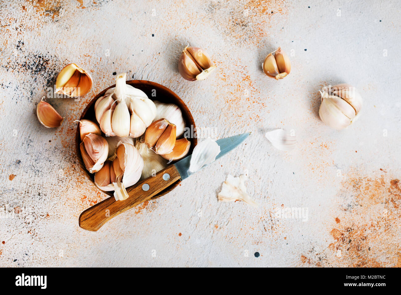 garlic in wooden bowl and on a table Stock Photo - Alamy