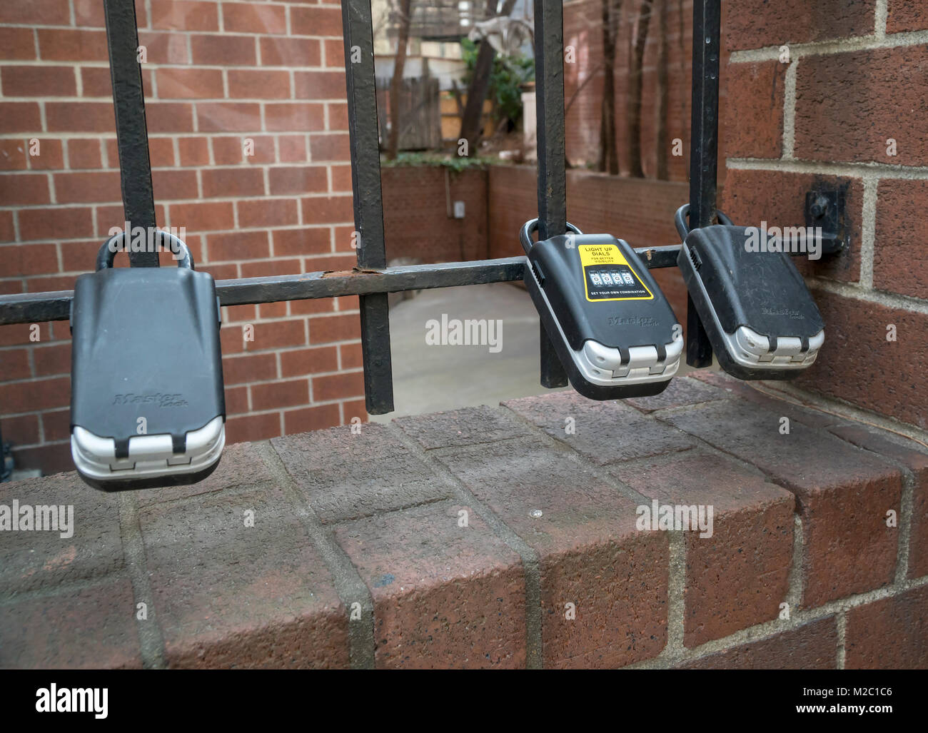 Lockboxes attached to a gate outside an apartment building in the