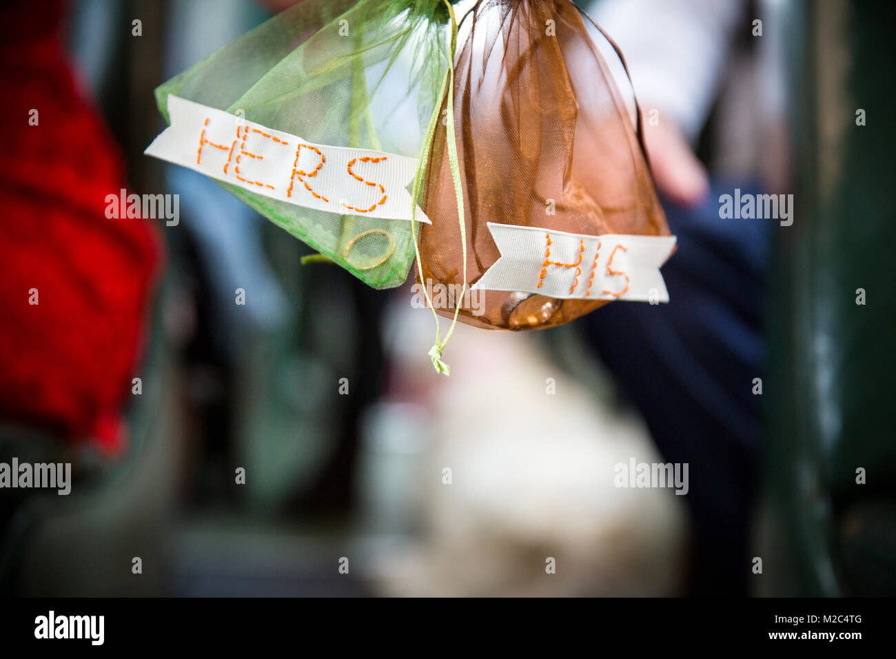 Two voile bags, containing wedding rings, with hand-stitched his and hers labels, close-up Stock Photo
