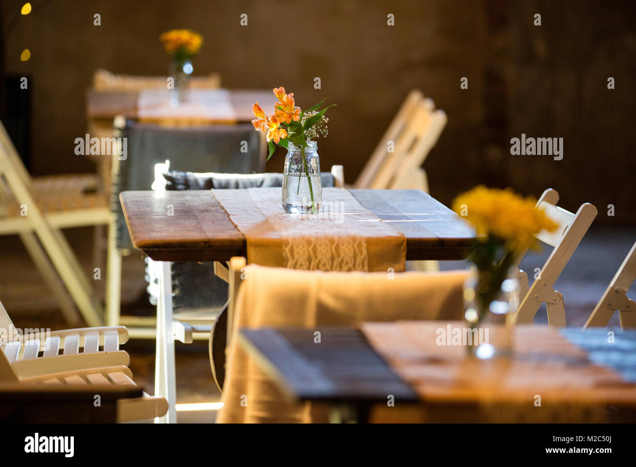 Tables set with vases of flowers Stock Photo