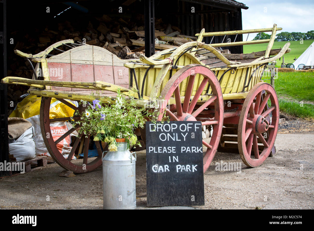 Painted horse-drawn cart with milk churn and car park sign Stock Photo