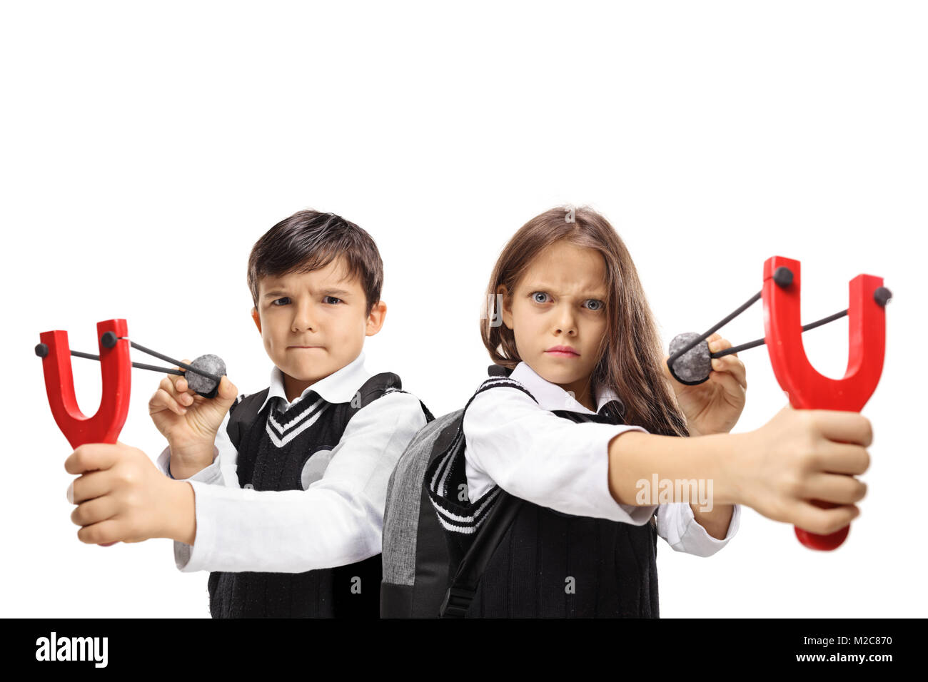 Schoolboy and a schoolgirl aiming with slingshots and rocks isolated on white background Stock Photo