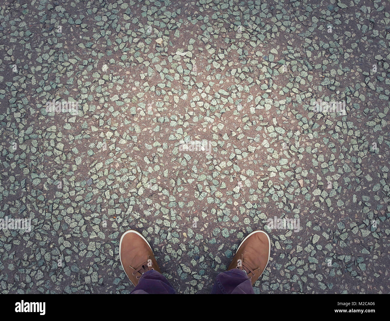 Man shoes on urban asphalt grunge background with copy space. Conceptual image of legs in boots outdoor on city street. Stock Photo