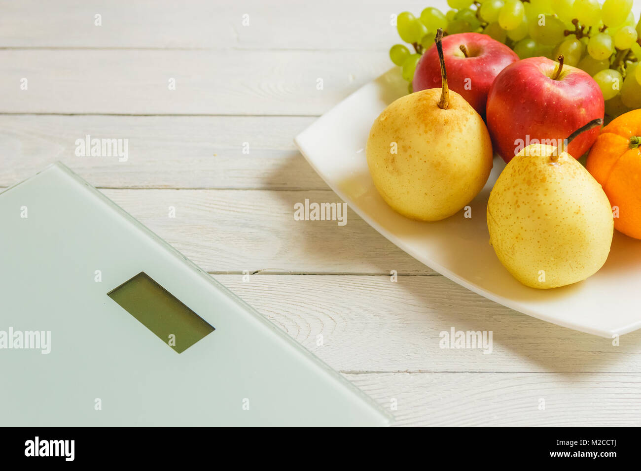 floor scale and fruits on wooden background Stock Photo