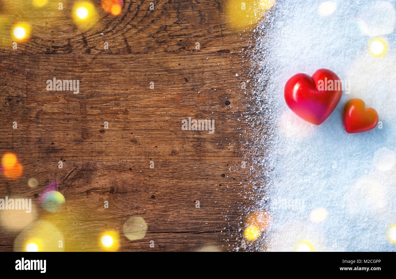 Two red hearts on snow and rustic background. Love and St. Valentines Day concept. Stock Photo