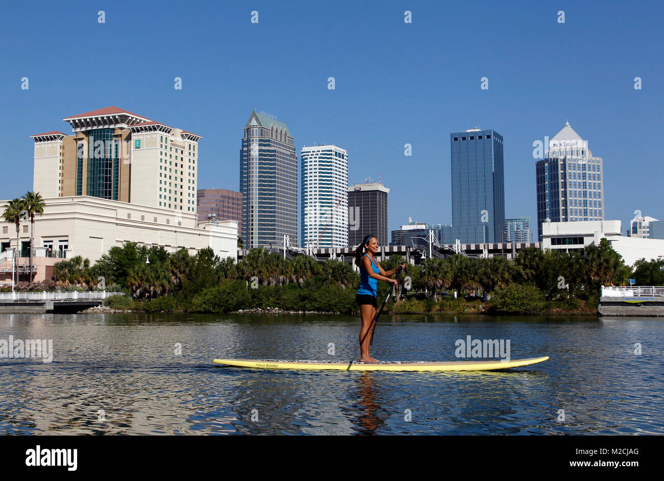 A paddle boarder coasts along a waterway next to downtown Tampa's Riverwalk. (Photo by Matt May/Alamy) Stock Photo