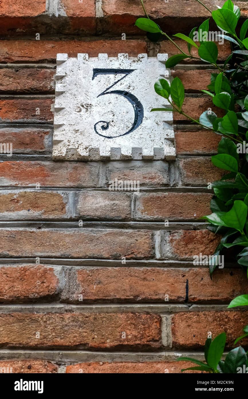 House number three, 3. In front of an ancient luxury residential apartment building in the Coppede quarter. Art Deco style. Rome, Italy, EU. Close up. Stock Photo