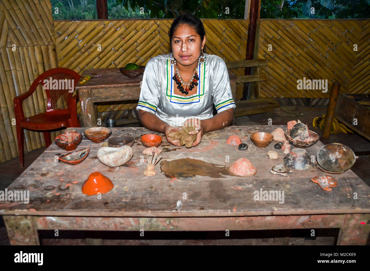 Local Quechua Ecuadorian indigenous woman displays pottery cups  Stock Photo