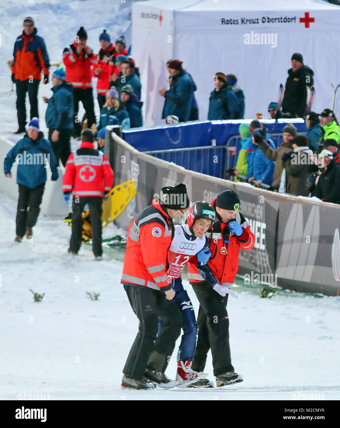 Der Japaner Reruhi Shimizu wird nach seinem Sturz von Sanitätern aus dem Auslauf begleitet -  Qualifikation für 63. Vierschanzentournee Auftaktspringen Oberstdorf Stock Photo