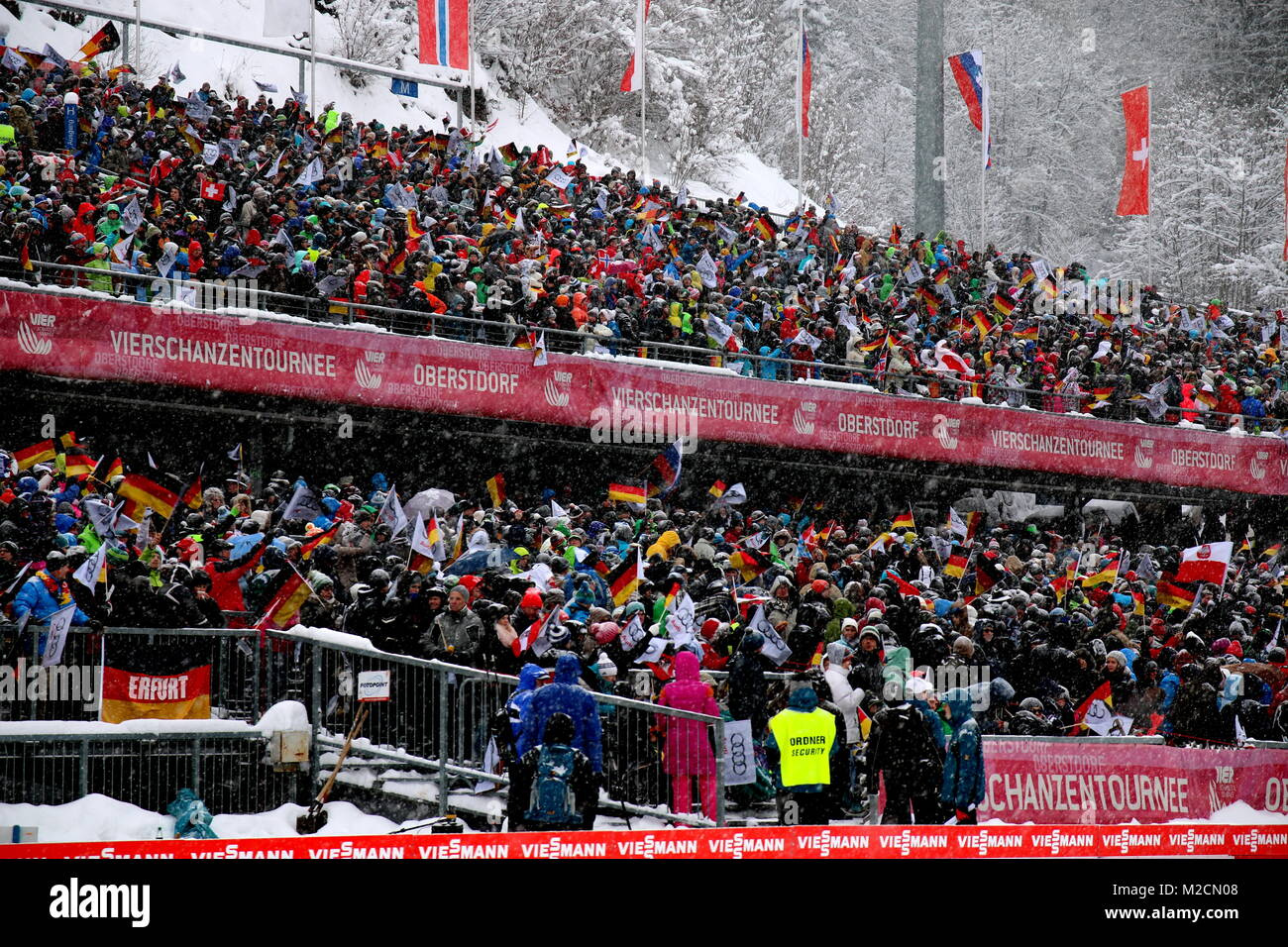 Gute Stimmung bei den Skisprungfans in der Allgäu Arena von Oberstdorf. Wegen starkem Schneefall musste der Probedurchgang um 30 Minuten verschoben werden. 1. Wettkampf der  63. Vierschanzentournee Auftaktspringen Oberstdorf Stock Photo