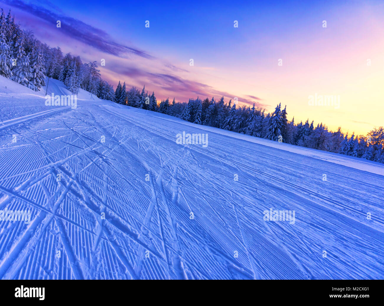 Sunset over the groomed cross country ski trail, dynamic shot. Dramatic sky glowing by sunlight.  Slovakia, Europe. Stock Photo