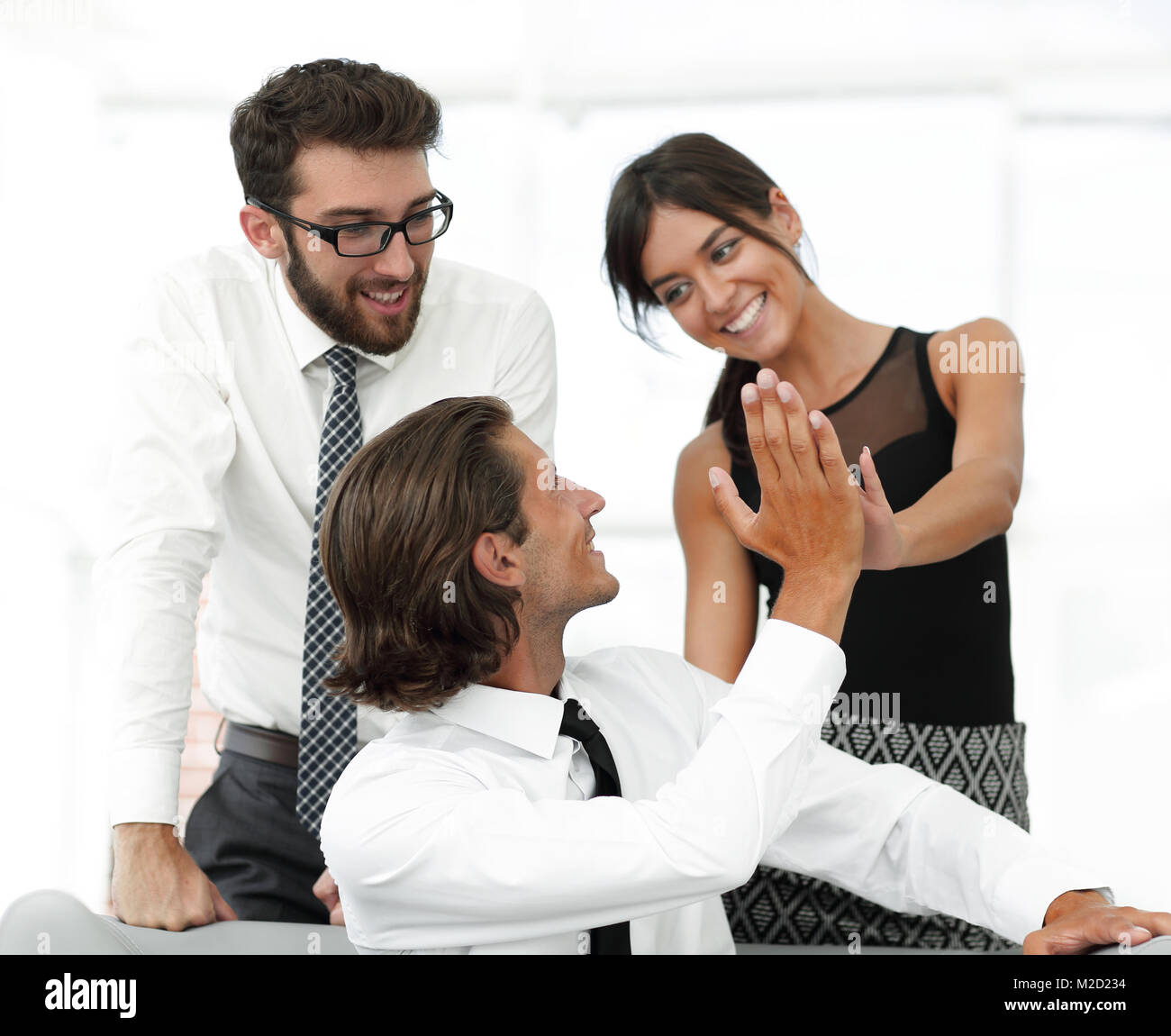Young business colleagues giving each other a high five Stock Photo - Alamy