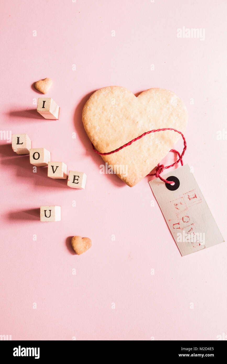 Beautiful heart shaped cookies for Valentine's day with a greeting' s card with ' i love u ' message and Letter stamps forming the phrase ' i love u'  Stock Photo