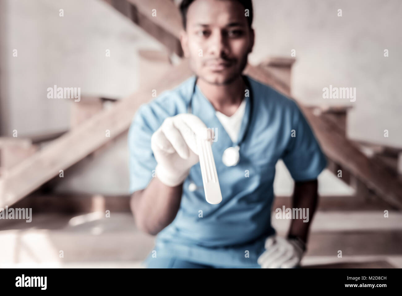 Doctor using wooden stick for throat checking Stock Photo Alamy