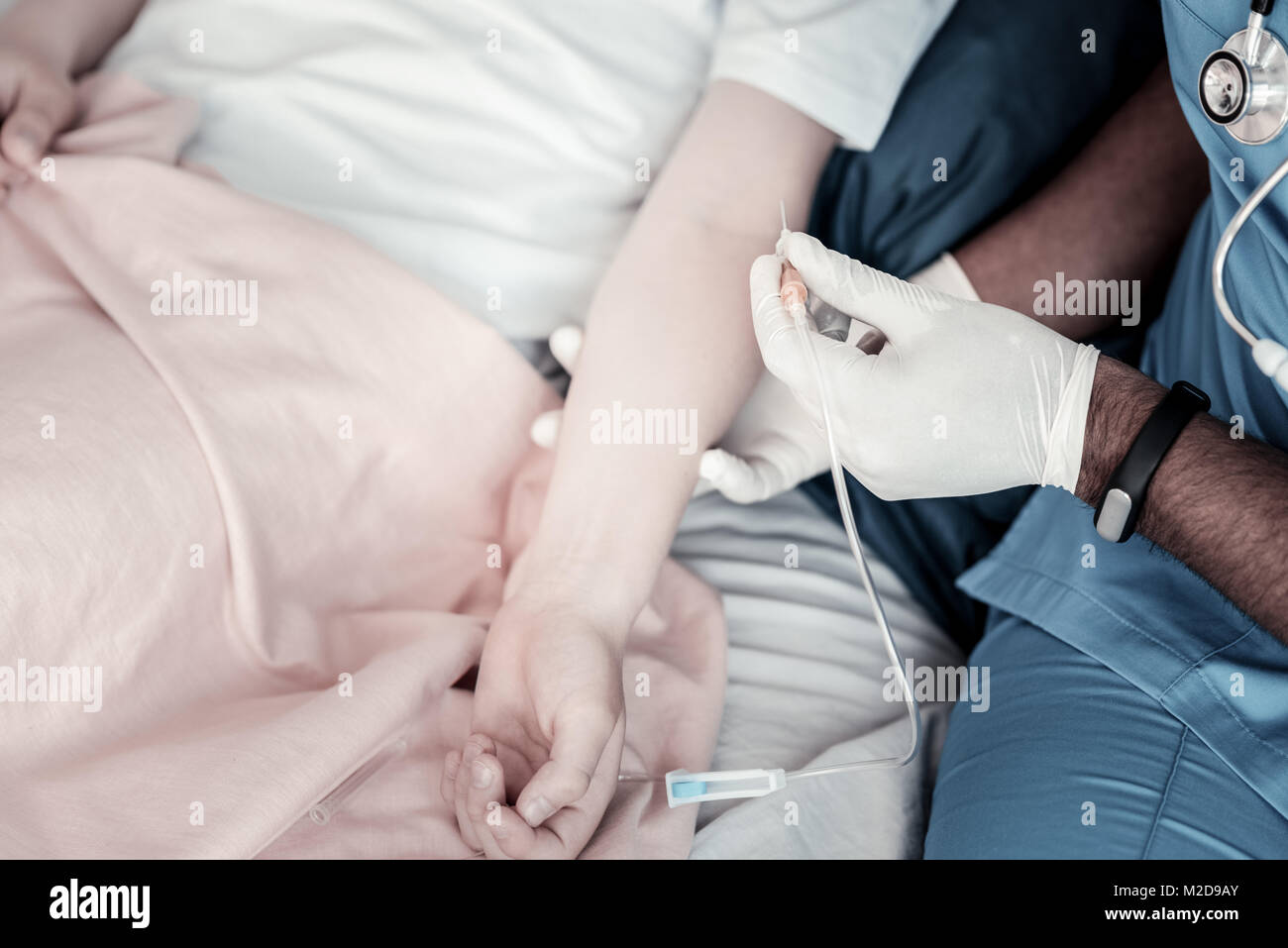 Scaled up look on physician inserting drip in arm Stock Photo - Alamy