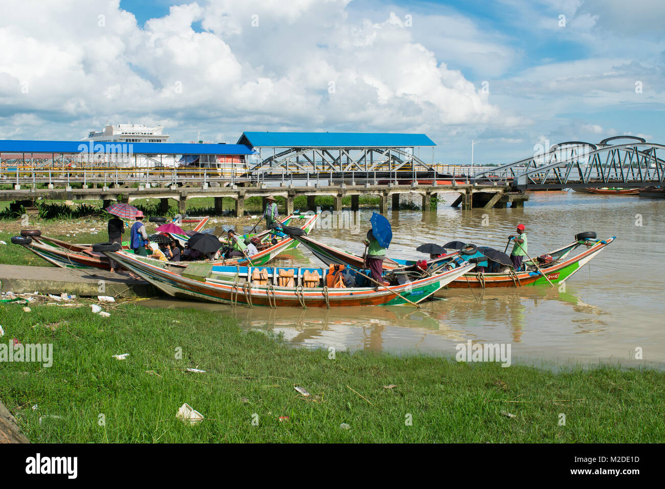 A boat arriving at Botahtaung jetty, carrying Burmese passengers on the Yangon River. brown river water, colorful boats, clean water transport, Burma Stock Photo