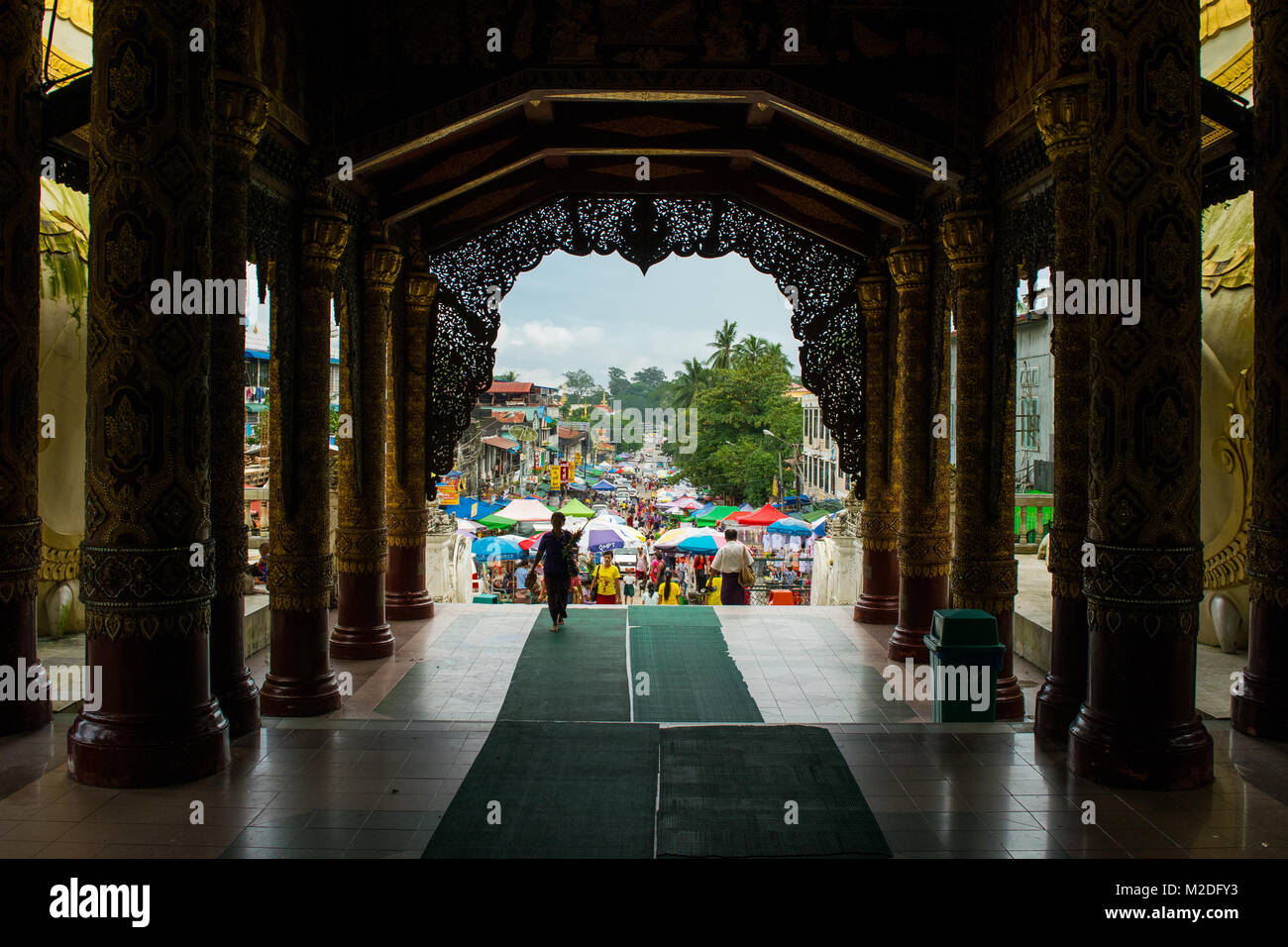 Exiting Shwedagon Pagoda and entering a busy hectic street market, filled with color umbrella stalls. Colorful Yangon, Burma, Myanmar, South East Asia Stock Photo