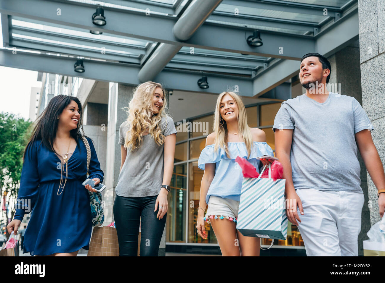 Friends carrying shopping bags in city Stock Photo