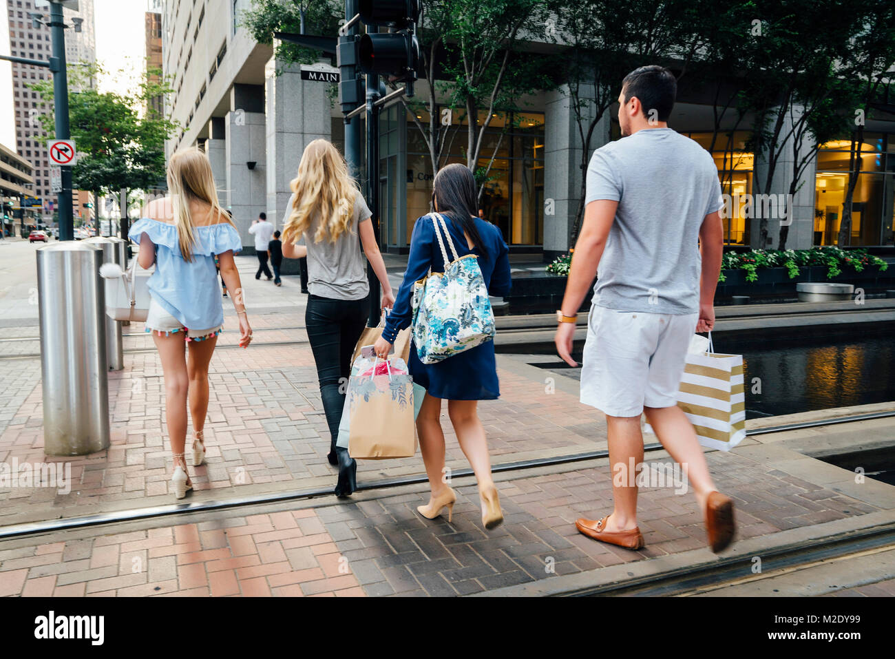 Friends crossing street in city carrying shopping bags Stock Photo Alamy