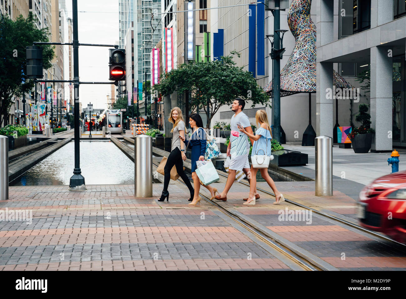 Friends crossing street in city carrying shopping bags Stock Photo Alamy