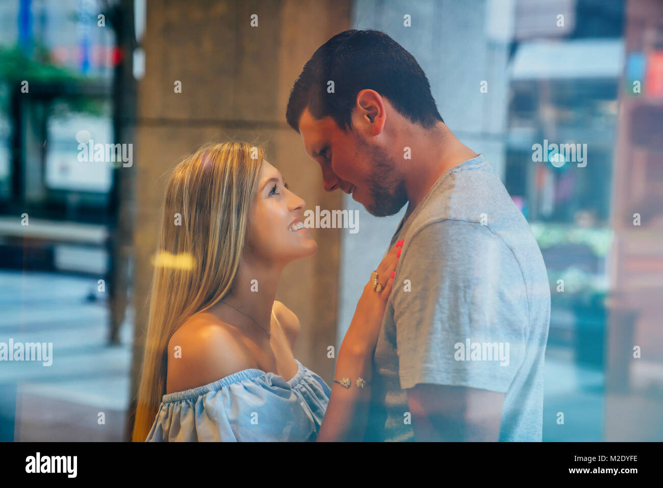 Smiling Caucasian couple behind window Stock Photo