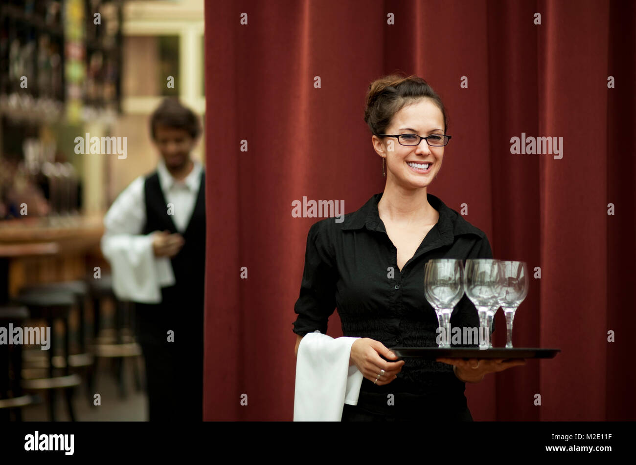 Smiling Hispanic waitress carrying tray of wine glasses Stock Photo Alamy