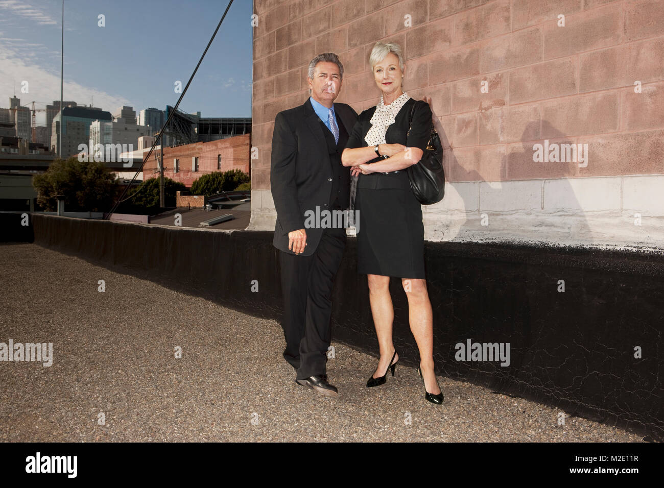 Portrait of confident business people standing near brick wall Stock Photo